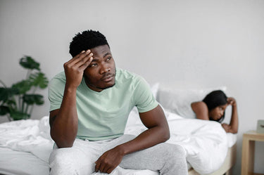 Man sad sitting in bed with woman