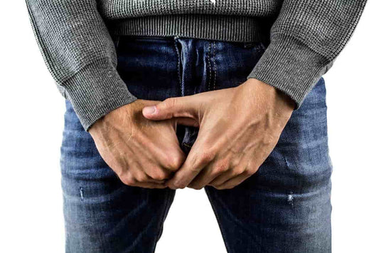 Man with blue balls holding testicles through jeans