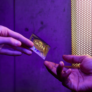 Hands passing top selling condoms from Promescent online store