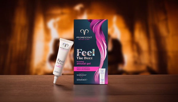 Promescent buzzing female arousal gel on a wooden table in front of a fireplace